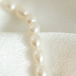 Closeup perle naturale de cultură albe rice shape pe brățară