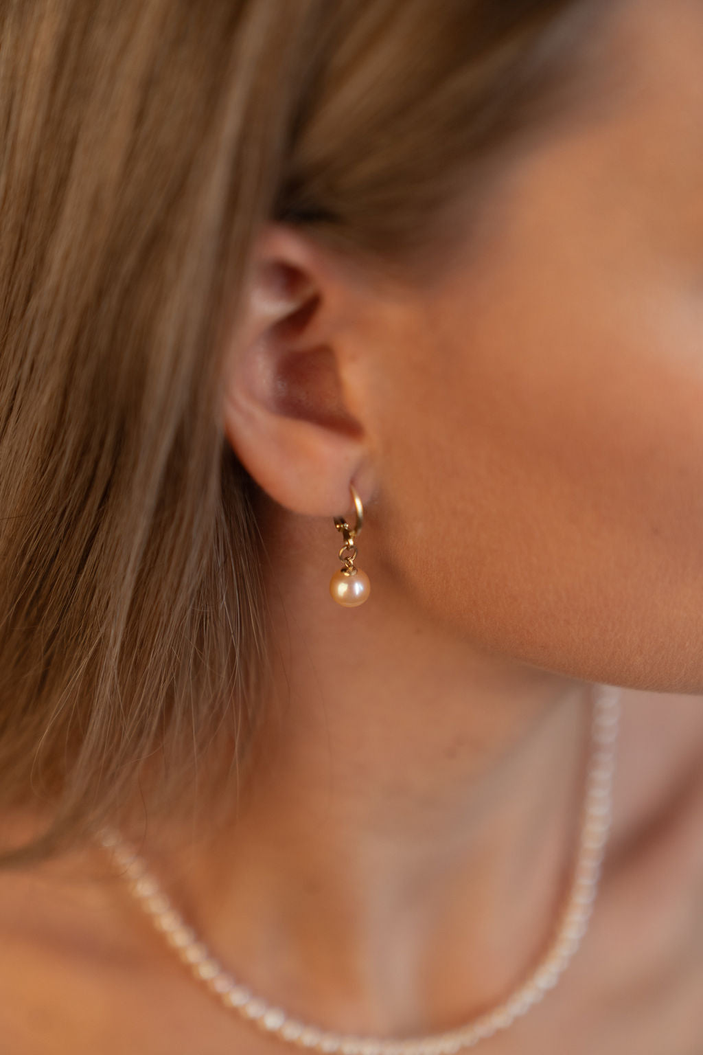 Cercei lungi cu perle naturale de cultură roz, purtați