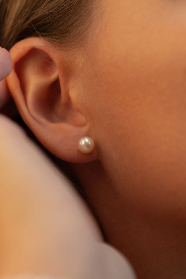 Cercei stud cu perle naturale de cultură champagne, purtați