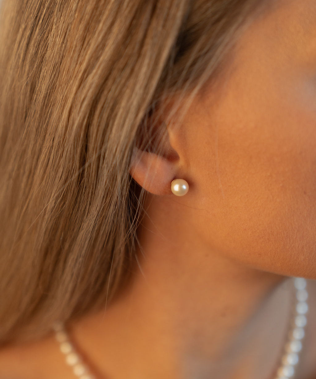 Cercei stud cu perle naturale de cultură champagne, purtați