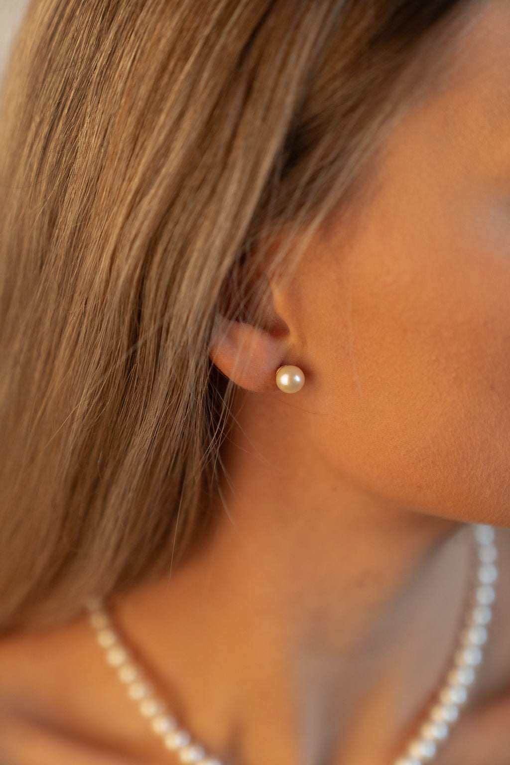 Cercei stud cu perle naturale de cultură champagne, purtați