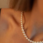 Colier elegant cu perle de cultură champagne, purtat la gât