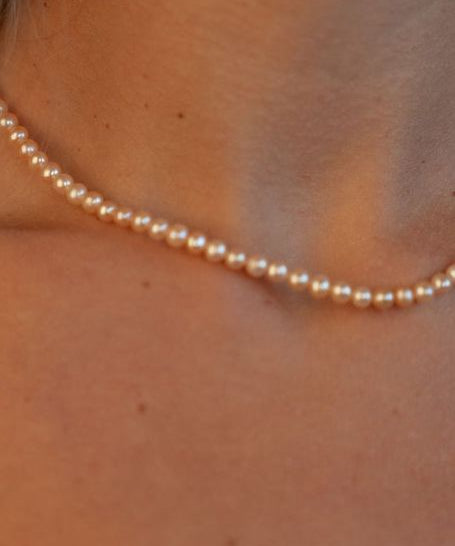 Colier cu perle de cultură roz, purtat la gât