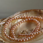 Detaliu colier cu perle de cultură roz, nuanță delicată