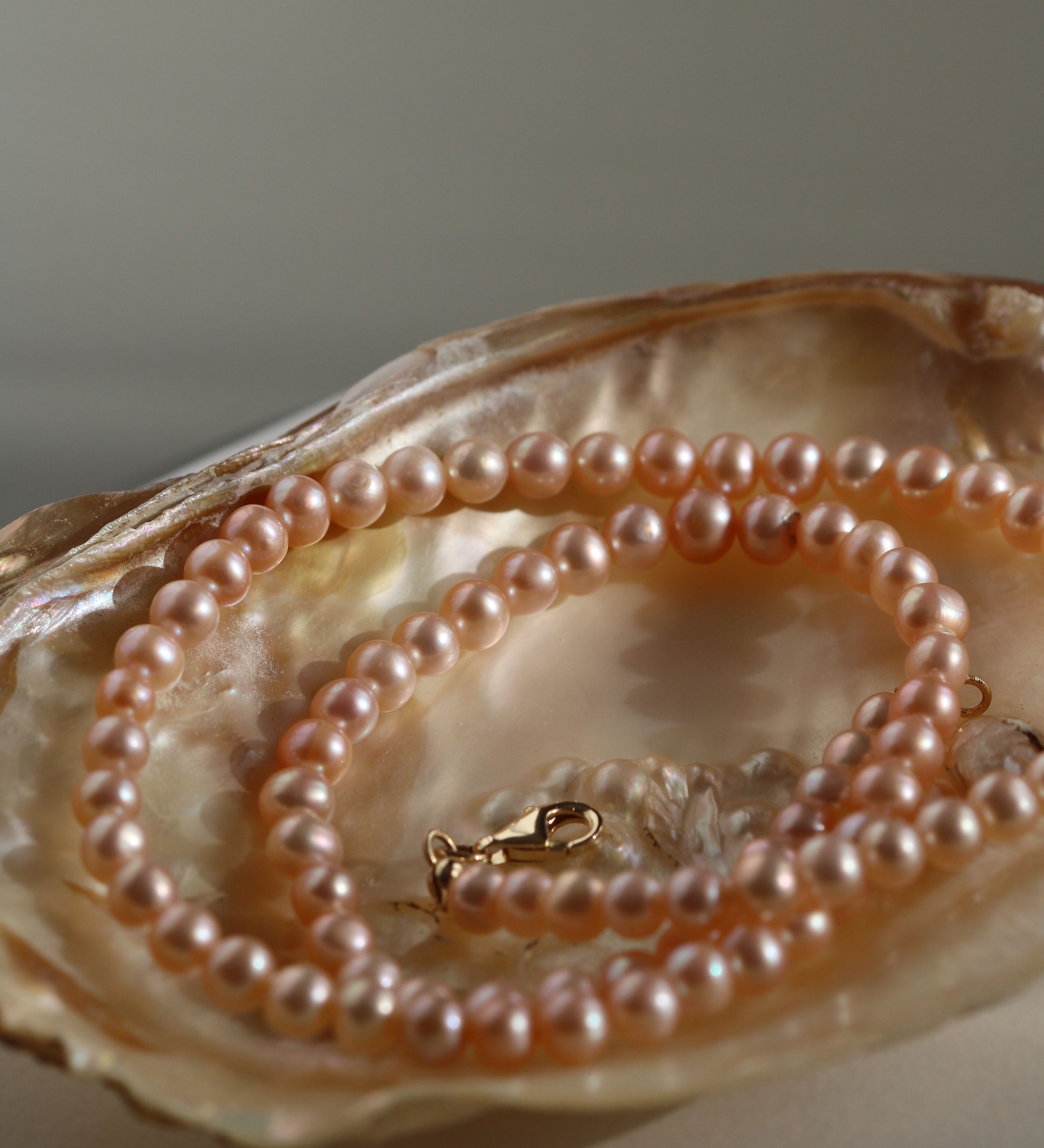 Detaliu colier cu perle de cultură roz, nuanță delicată