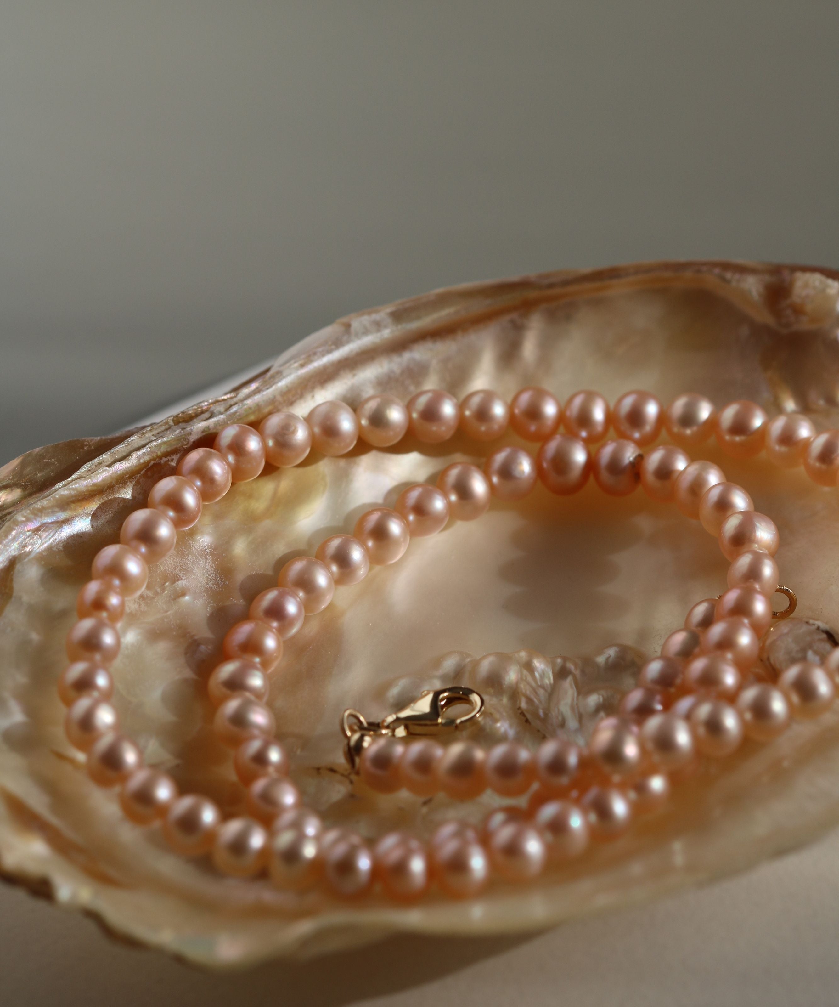 Detaliu colier cu perle de cultură roz, nuanță delicată