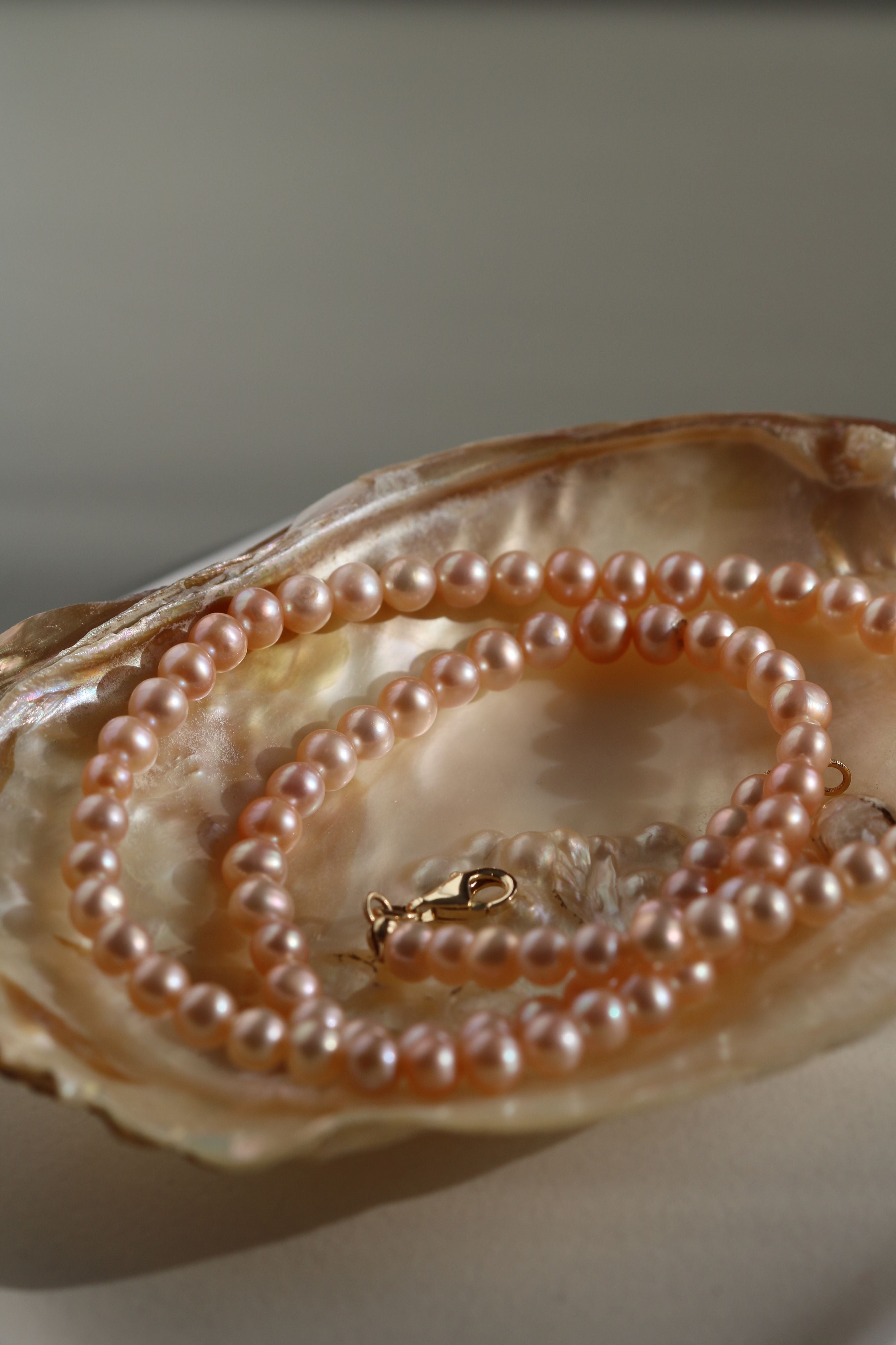 Detaliu colier cu perle de cultură roz, nuanță delicată