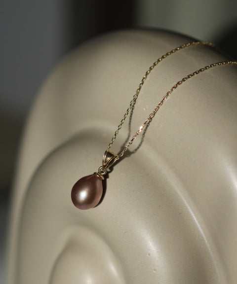 Pandantiv cu perlă naturală mov într-un cadru de prezentare elegant