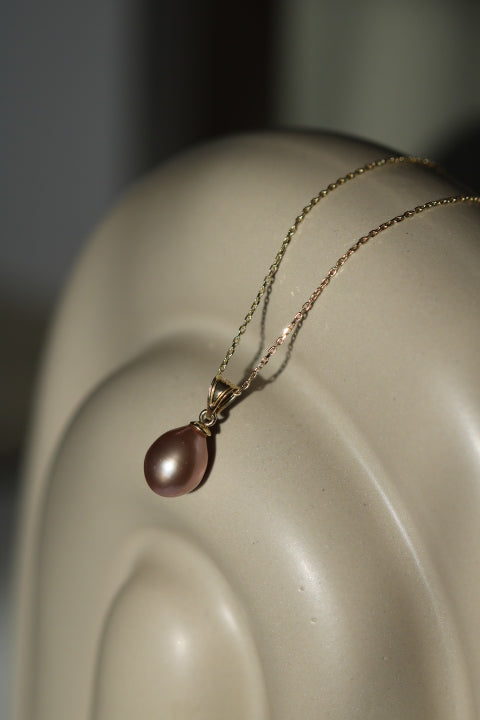 Pandantiv cu perlă naturală mov într-un cadru de prezentare elegant