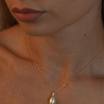 Pandantiv delicat cu perlă naturală albă într-un cadru lifestyle