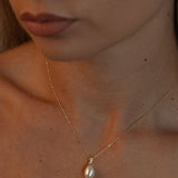 Pandantiv delicat cu perlă naturală albă într-un cadru lifestyle