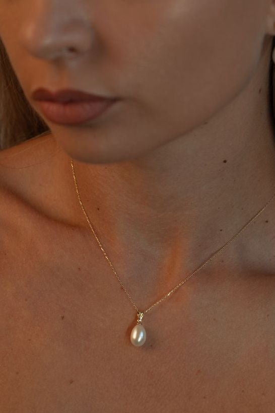 Pandantiv delicat cu perlă naturală albă într-un cadru lifestyle