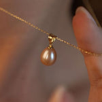 Pandantiv cu perlă naturală roz, purtat la gât